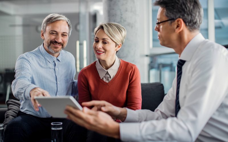 happy-mid-adult-couple-using-touchpad-with-their-financial-consultant-in-the-office-.jpg happy-mid-adult-couple-using-touchpad-with-their-financial-consultant-in-the-office-.jpg